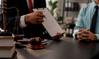 Lawyer legal advisor counsel presents to the client a signed contract with gavel and legal law. justice and lawyer Business partnership meeting concept.
