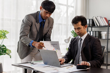 Entrepreneur TWO Asian businessman discussing new business project in tablet in modern Meeting In Modern Office, Asian business casual concept.
