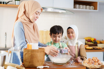 Asian muslim woman and lovely children are preparing and cooking in the kitchen.