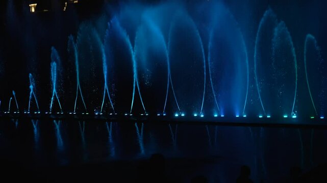 A mesmerizing musical fountain show with vibrant blue and red lights at Vinpearl, Nha Trang, creating a magical nighttime experience.