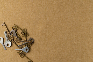 Collection of decorative aged keys on fabric background. Flat lay, top view. Copy space
