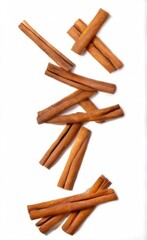 Cinnamon sticks arranged in a zigzag pattern on white background, varying in sizes and shapes with a goldenbrown color.