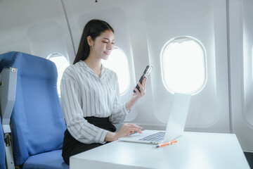 Fototapeta premium A businesswoman sits by the airplane window. She enjoys a luxurious travel experience that symbolizes success, adventure, and the excitement of traveling to new destinations.