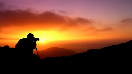 Silhouette of a photographer taking a picture of a scenic sunset