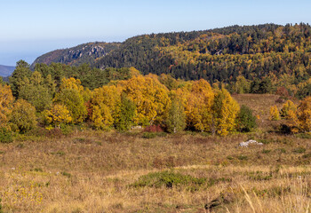 autumn, the morning light of the rising sun illuminates the alpine meadows and the slopes of the...