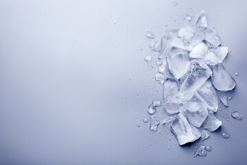 Pieces of crushed ice on light blue background, top view. Space for text