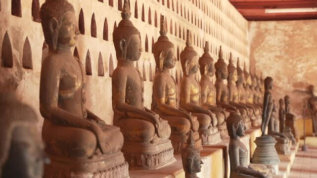 Sunlight falls on rows of Buddha statues in Wat Sisaket temple