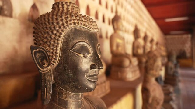 Statue with closed eyes and row of similar figures along wall