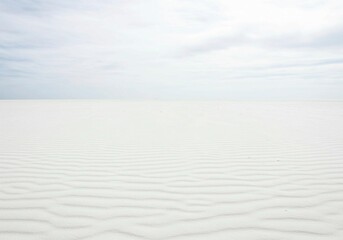 Fototapeta premium The minimalist beauty of white sand is highlighted in this image, featuring distinct ripple patterns and natural lighting