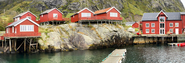 wooden house on red stilts typical of the villages in the archipelago of Lofoten by the water with...