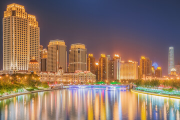 Naklejka premium The urban architectural skyline, modern bridges, and Haihe River night scenery of Tianjin, China on August 11, 2024