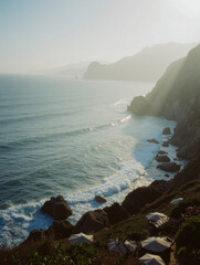 Scenic coastal landscape with rocky cliffs and ocean waves at sunset