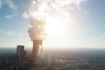Industrial plant with cooling towers and smoke