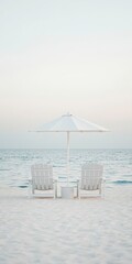 Fototapeta premium Simple beach scene with white chairs and a parasol under soft pastel skies, with calm waters stretching to the horizon
