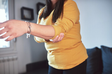 Woman with arm and elbow pain at home.