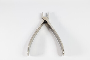 Stainless steel pliers for tooth extraction. The forceps in this photo are for extracting an upper anterior tooth. Photographed against a white background.