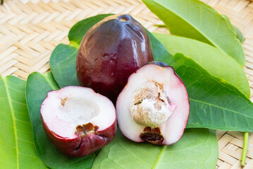 Syzygium malaccense rose apple, large, dark red fruit, white flesh inside, sour taste, rose apple grows on a basket.