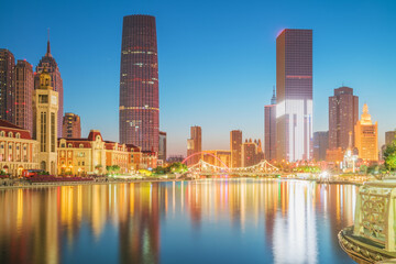 Naklejka premium The urban architectural skyline, modern bridges, and Haihe River night scenery of Tianjin, China on August 11, 2024 ﻿