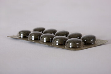 Activated Charcoal Tablets Pills In Blister Pack Isolated On White, Strip of 10 pills on white background