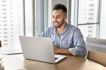 Fototapeta premium Man using laptop for telework, videocall meeting event by personal or business matters, buying goods through marketplace, studying via educational platform. Artificial intelligence, modern tech, hobby