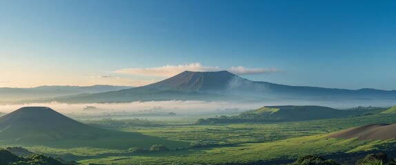 Fototapeta premium Majestic volcanic landscape under a clear sky with lush greenery and rolling hills.
