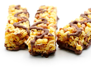 Delicious cereal bars with chocolate against the white background