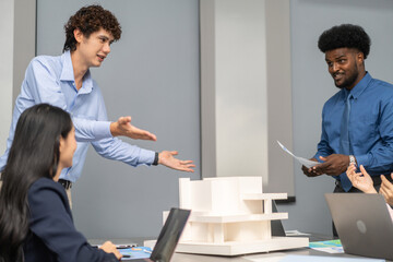 Architects engineers collaborating on building design project in modern office, diverse team of professionals female muslim architect and male engineers discussing architectural model of structure
