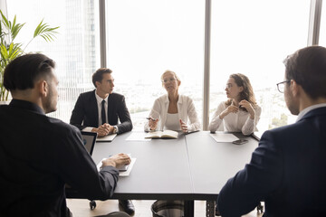 Leading round table discussion. Experienced mid aged businesswoman leader mentor teacher speak to...