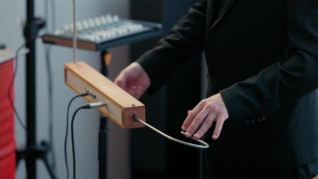 Playing the theremin. The theremin, etherphone, thereminophone or termenvox, thereminvox, is an electronic musical instrument controlled without physical contact by the performer. Patented in 1928