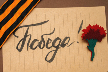 9 May. Red Carnation, Notepad, George ribbon. Russian translation of the inscription: Victory.