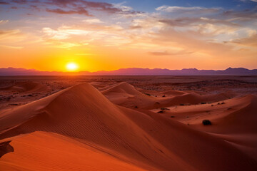 Fototapeta premium Sunset Over Rolling Sand Dunes with Sparse Vegetation