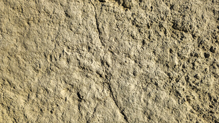 A yellow and rough wall in the sunlight