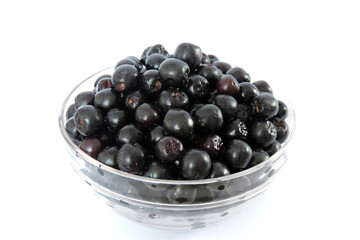 Fresh ripe aronia berries decorated in a glass bowl, white background, isometric view