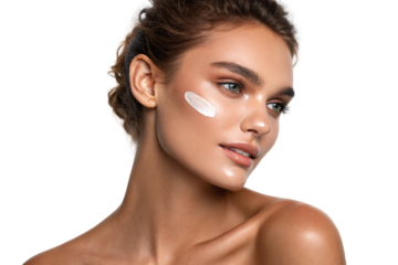 A woman with glowing, flawless skin and high cheekbones applies a streak of white cream to her cheek, showcasing radiant beauty with a confident, serene expression, isolated on transparent background