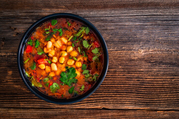 Fresh vegetable soup with chickpea on wooden table
