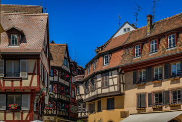 Ornate traditional half timbered houses with blooming flowers along the canals, Little Venice district in Colmar, picturesque village in Alsace France