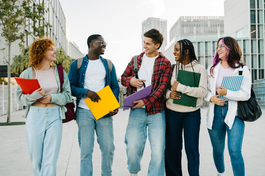 Group of diverse university student friends walking going to classes on college campus. Diversity in school and education