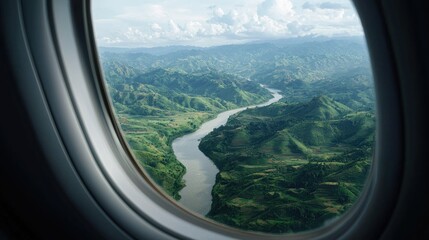 Fototapeta premium Aerial view of a river winding through green mountains, seen from an airplane window. Travel and nature concept.