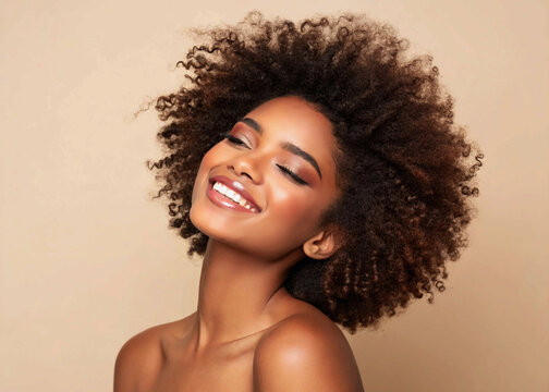 Beauty portrait of african american girl with clean healthy skin on beige background. Smiling dreamy beautiful black woman.Curly hair in afro style