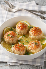 Chicken piccata meatballs with a delicious sauce of lemon, capers, white wine, and butter closeup in the plate on the table. Vertical