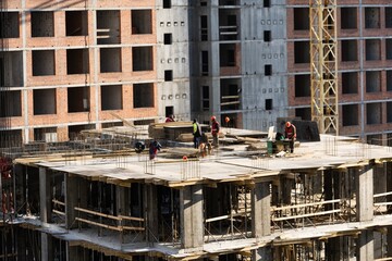 concreting work: construction site worker during concrete pouring into formwork at building area...