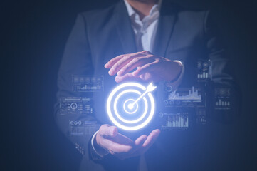 Businessman hand holding goal growth target icon and background of success graph financial profit...