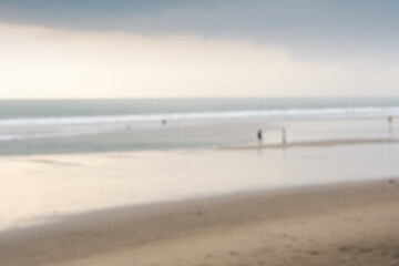 Blurry background of people at beach with cloudy at sunset