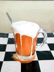 white cream overflowing out of hot tea cup