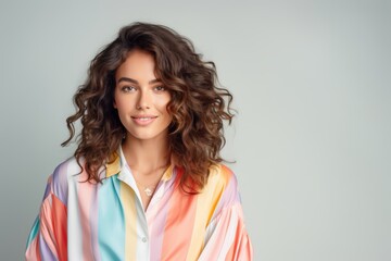 Fototapeta premium A woman with curly hair is wearing a colorful striped shirt