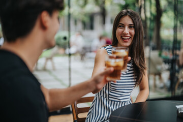 A happy woman enjoying a refreshing drink with a friend outdoors. The atmosphere is casual, friendly, and relaxed, highlighting friendship and leisure time in a lively setting.