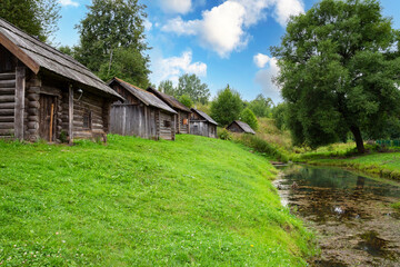 Medieval complex of traditional wooden baths reflected in the water on the bank of the river in the village of Vyatskoye in Yaroslavl region in Russia in the summer
