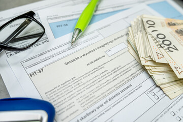Obraz premium Polish tax form pit 36 PIT-37 pit 38 with pen calculator glasses on accountant table. Taxation concept