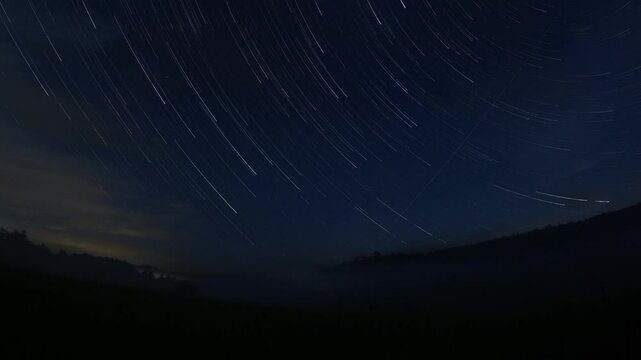 star trails shot on action camera,European sky night panorama time lapse under Tocnik medieval castle ruins on a mountain with fogs in the valley cold summer morning
