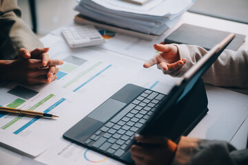 Two young Asian business woman talk, consult, discuss working with new startup project idea presentation analyze plan marketing and investment in the office.